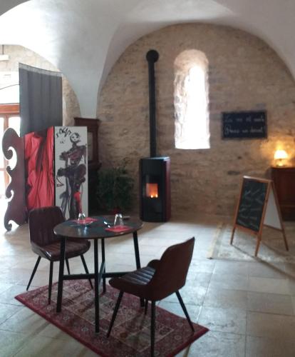 - une table et des chaises dans une pièce dotée d'une cheminée dans l'établissement LA GRANGE TEMPLIERE 2018, à Peyreleau