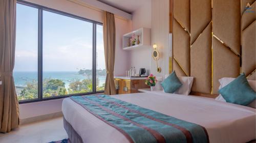 um quarto de hotel com uma cama e uma grande janela em Hotel Atlanta - A Seaview Hotel em Port Blair