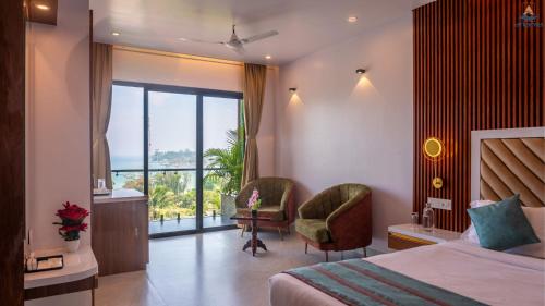a hotel room with a bed and a chair and a window at Hotel Atlanta - A Seaview Hotel in Port Blair