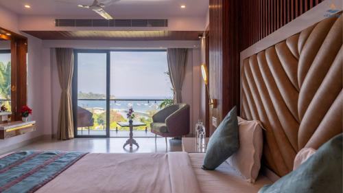 a bedroom with a bed with a view of the ocean at Hotel Atlanta - A Seaview Hotel in Port Blair