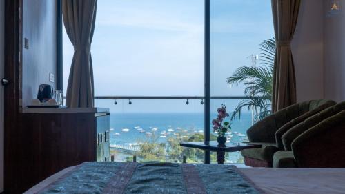 a bedroom with a bed and a view of the ocean at Hotel Atlanta - A Seaview Hotel in Port Blair
