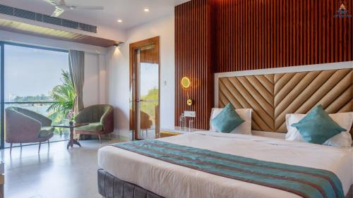 a bedroom with a large bed and a balcony at Hotel Atlanta - A Seaview Hotel in Port Blair