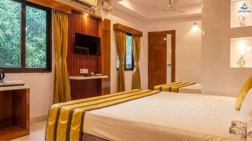 a hotel room with a bed and a television at Hotel Atlanta - A Seaview Hotel in Port Blair