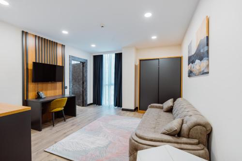 a living room with a couch and a desk at Best Western Plus Batumi in Batumi
