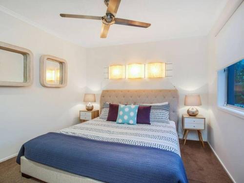 1 dormitorio con 1 cama con edredón azul y blanco en Bliss At The Bungalow, en Gold Coast