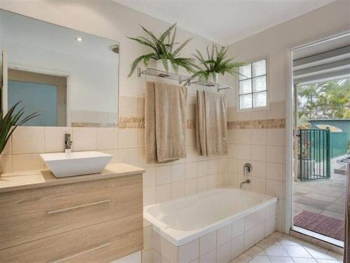 y baño con bañera, lavabo y espejo. en Bliss At The Bungalow, en Gold Coast