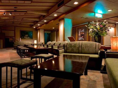 a hotel lobby with couches and tables and flowers at Ryumontei Chiba Ryokan in Ōyu