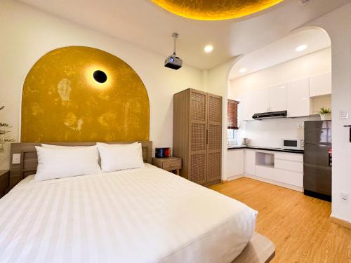 1 Schlafzimmer mit einem großen Bett und einer Küche in der Unterkunft AIRIE LIVING in Ho-Chi-Minh-Stadt