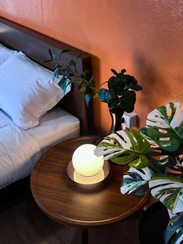 a table with a lamp and a plant on top of a bed at Jaruchok Apartment in Bangkok