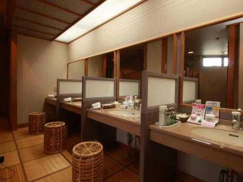 a bathroom with three sinks and a large mirror at Ryumontei Chiba Ryokan in Ōyu