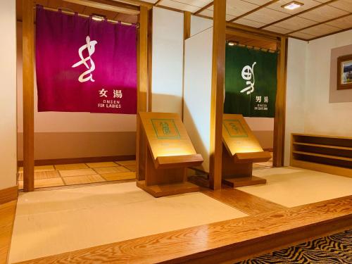 two benches in a room with signs on the wall at Ryumontei Chiba Ryokan in Ōyu