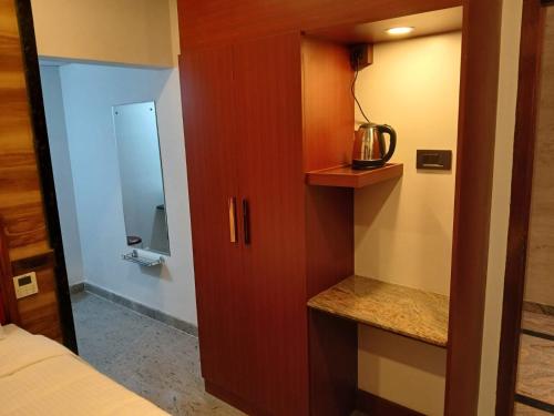1 dormitorio con armario, 1 cama y 1 habitación en Ramraj Resort en Kanyakumari