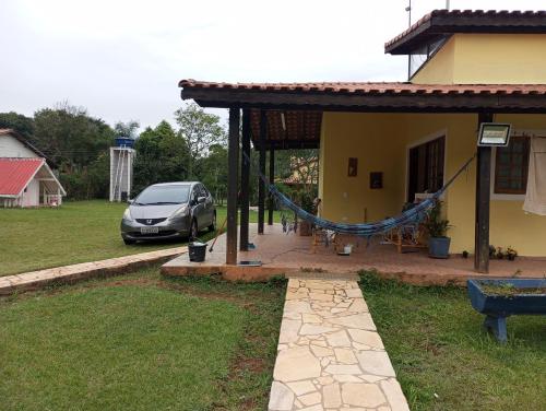a car parked next to a house with a hammock at Chácara linda em Extrema in Extrema