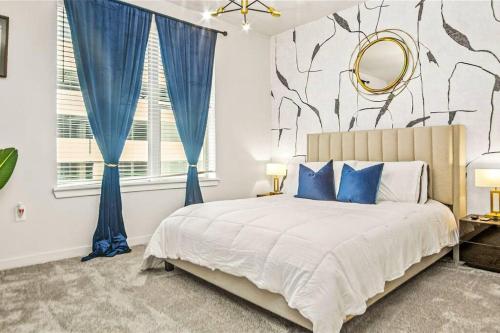 1 dormitorio con 1 cama con cortinas azules y espejo en Contemporary LUX 1BD Downtown, en Dallas