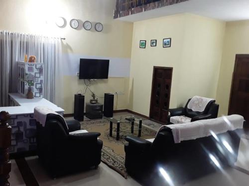 a living room with two chairs and a television at Cardamom rock inn Holidays in Pīrmed
