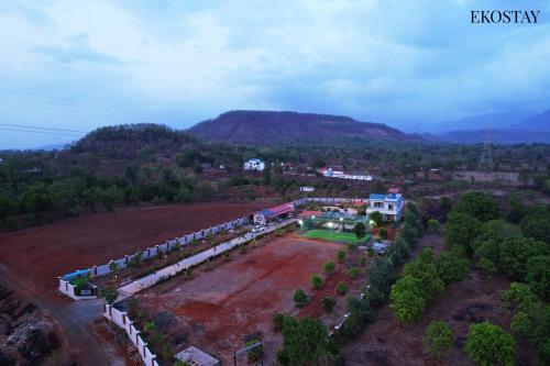 an aerial view of a train yard with a mountain at Ekostay Gold Palm Estate I Cricket Turf I Rain Dance I 2 Acre Property in Karjat