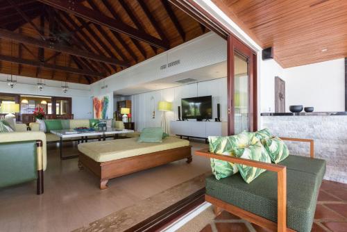 a living room with a couch and a table and a tv at Miskawaan Luxury Beachfront Villas in Mae Nam