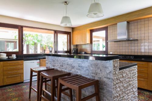 a kitchen with a bar with stools in it at Miskawaan Beachfront Villas in Mae Nam