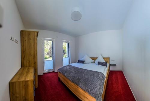 a bedroom with a large bed and two windows at Ferienwohnung - Riesling Ambiente - im Weingut Andries in Ernst