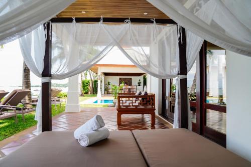 a bedroom with a bed and a view of a pool at Miskawaan Beachfront Villas in Mae Nam