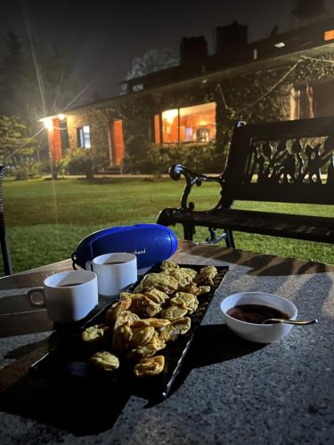 a tray of pretzels on a table next to a bench at Cedar Lodge By Aahma in Rāmgarh