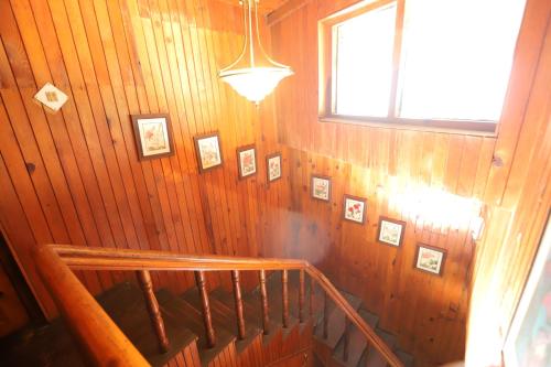 a staircase in a house with pictures on the wall at Cedar Lodge By Aahma in Rāmgarh