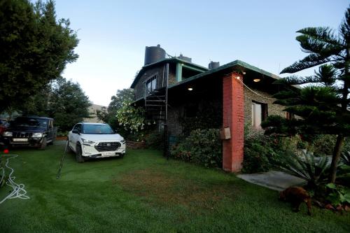 a car parked in front of a house at Cedar Lodge By Aahma in Rāmgarh