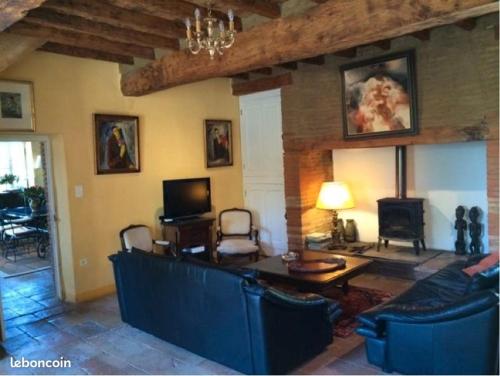ein Wohnzimmer mit einem Sofa und einem Tisch in der Unterkunft Domaine Le Clos du Figuier Spa in Verdun-sur-Garonne