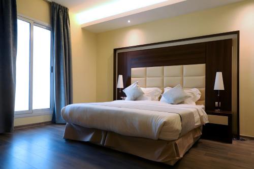 Helat Hotel في الخبر: غرفة نوم بسرير كبير مع اللوح الأمامي كبير