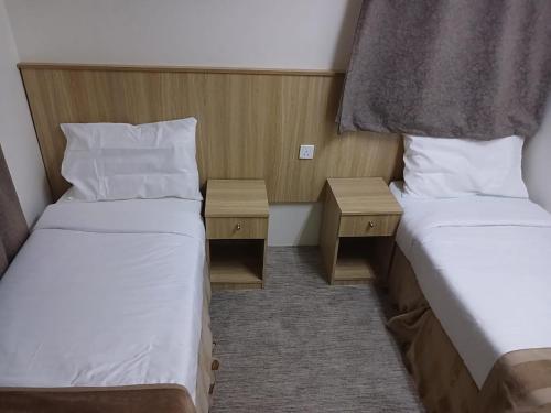 a small room with two beds and two night stands at فندق سما السماح Sama Al Samah Hotel in Makkah