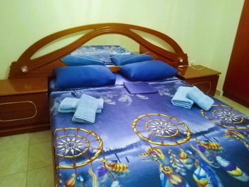 a bed with blue sheets and blue pillows on it at Jordan's Neoi Epivates Appartment by the Beach in Neoi Epivates