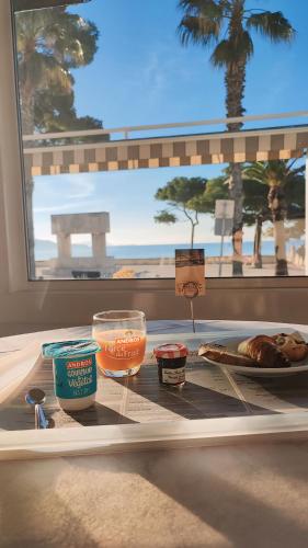 un plateau avec de la nourriture sur une table devant une fenêtre dans l'établissement Hotel Restaurant Miramar L'orchidée, à La Ciotat