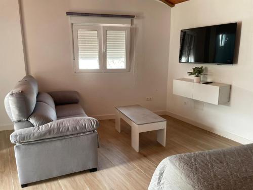 uma sala de estar com um sofá e uma mesa em Apartamento Isabel em Ardales