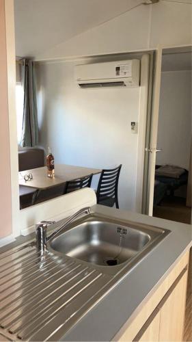 - une cuisine avec un évier en acier inoxydable dans l'établissement Mobil-home Camping - La Marine - Grau du Roi, au Grau-du-Roi