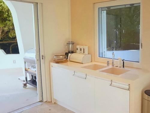 uma cozinha com um lavatório e uma janela em Casa ONTINO em Sabaudia