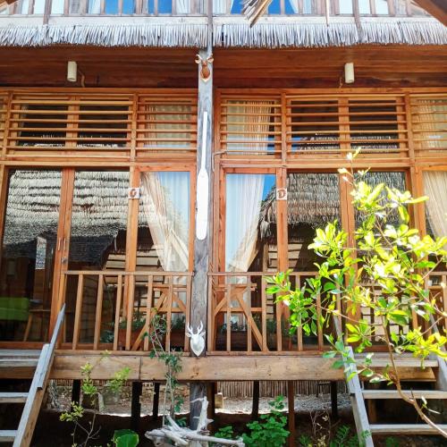 a window of a house with a staircase in it at Sunset Moyo Bungalows in Moyo Island