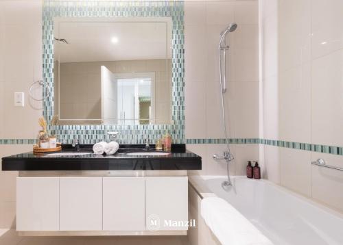 a bathroom with a tub and a sink and a mirror at Manzil - 2BR in Dubai Marina with Sea and Marina View in Dubai