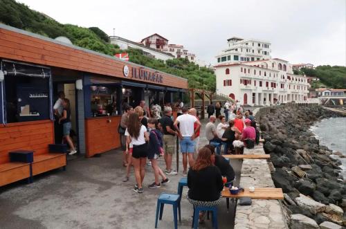 a group of people standing outside of a restaurant at Maisonnette à 5mn des plages. in Guéthary