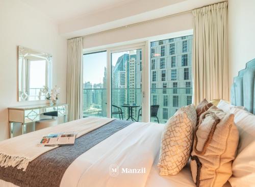a bedroom with a large bed and a large window at Manzil - 2BR in Dubai Marina with Sea and Marina View in Dubai