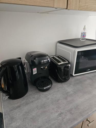 a kitchen counter with a toaster and a microwave at Studio de 23 m² au centre de Montfort L'amaury in Méré