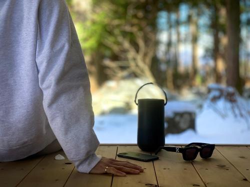 a person sitting on a wooden floor with a candle and sunglasses at サウナ付き一棟貸し宿 大岡辻-tsuji oooka- in Ookanakamaki