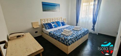 een kleine slaapkamer met een bed en een tafel bij Isola Blu Casa a pochi passi dal mare in Isola delle Femmine