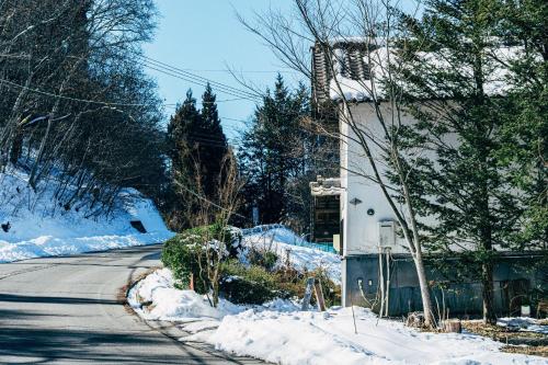 a street with snow on the side of a building at サウナ付き一棟貸し宿 大岡辻-tsuji oooka- in Ookanakamaki