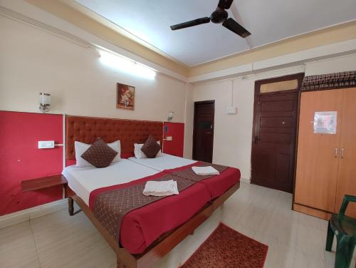 Schlafzimmer mit einem großen Bett mit einem roten Kopfteil in der Unterkunft Sanman Hotels in Vasco Da Gama