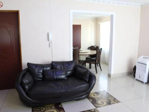 a black leather couch sitting in a living room at Amariah Guest House in Kasane