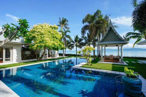 a villa with a swimming pool and a gazebo at Miskawaan Beachfront Villas in Mae Nam