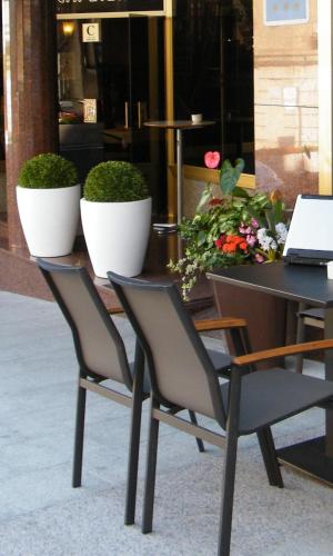 two chairs and a table with a laptop on it at Oca Ipanema Hotel in Vigo