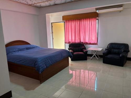 een slaapkamer met een bed en 2 stoelen en een raam bij My Hotel Bangkok Noi in Bangkok Noi