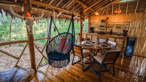 uma sala de jantar com uma rede de descanso num camarote em Carabao Lodge - 2 bedroom house, stargazing & pool em El Nido