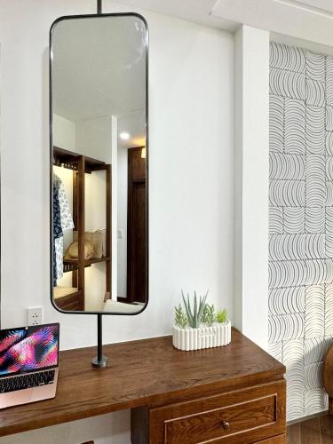 a mirror on top of a wooden dresser in a room at Tropicana Hồ Tràm - Seashell Villa in Ho Tram